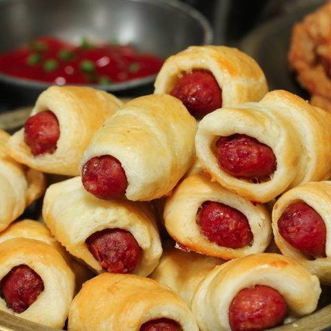 PIGS IN A BLANKET stacked on plate with dipping sauce