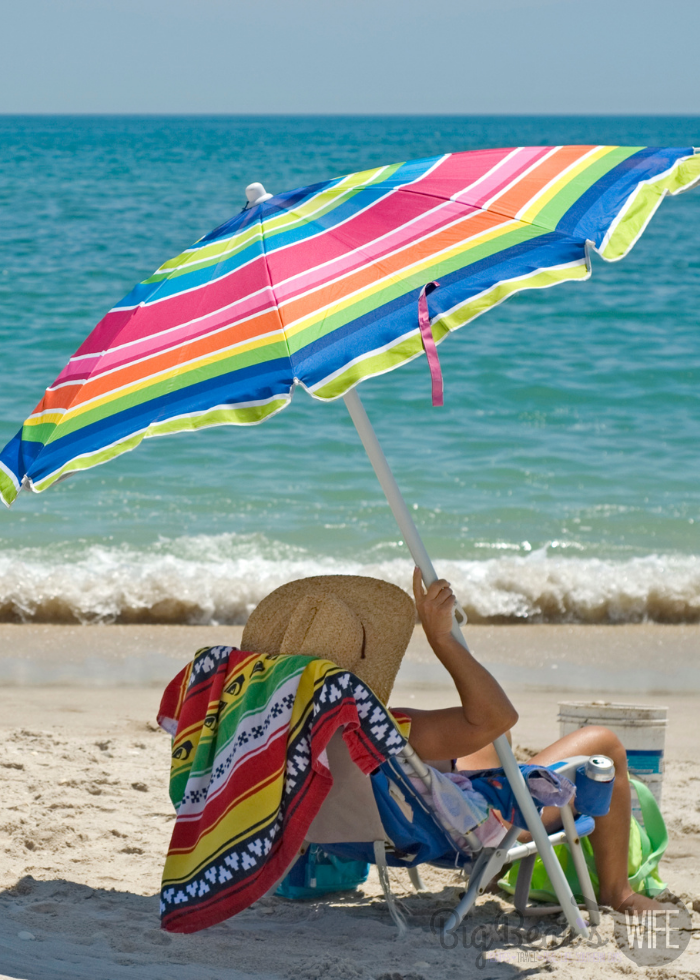 Rainbow Beach Umbrella with person and chair on beach