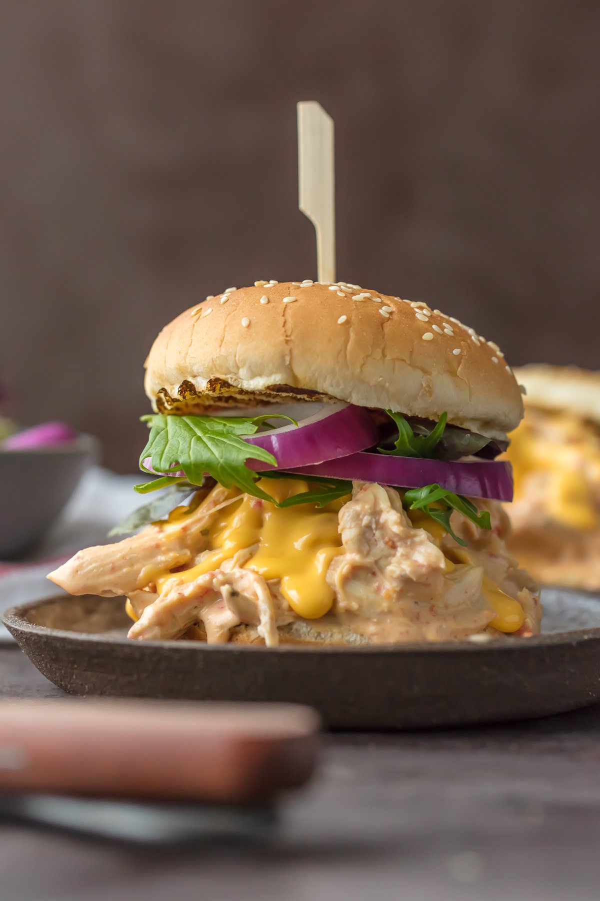 SLOW COOKER ROTEL DIP CHICKEN SANDWICHES are the ultimate way to tailgate for the Super Bowl! Spicy Cheesy Chicken Sandwiches made in the crockpot. SO MUCH FLAVOR! So addicting.