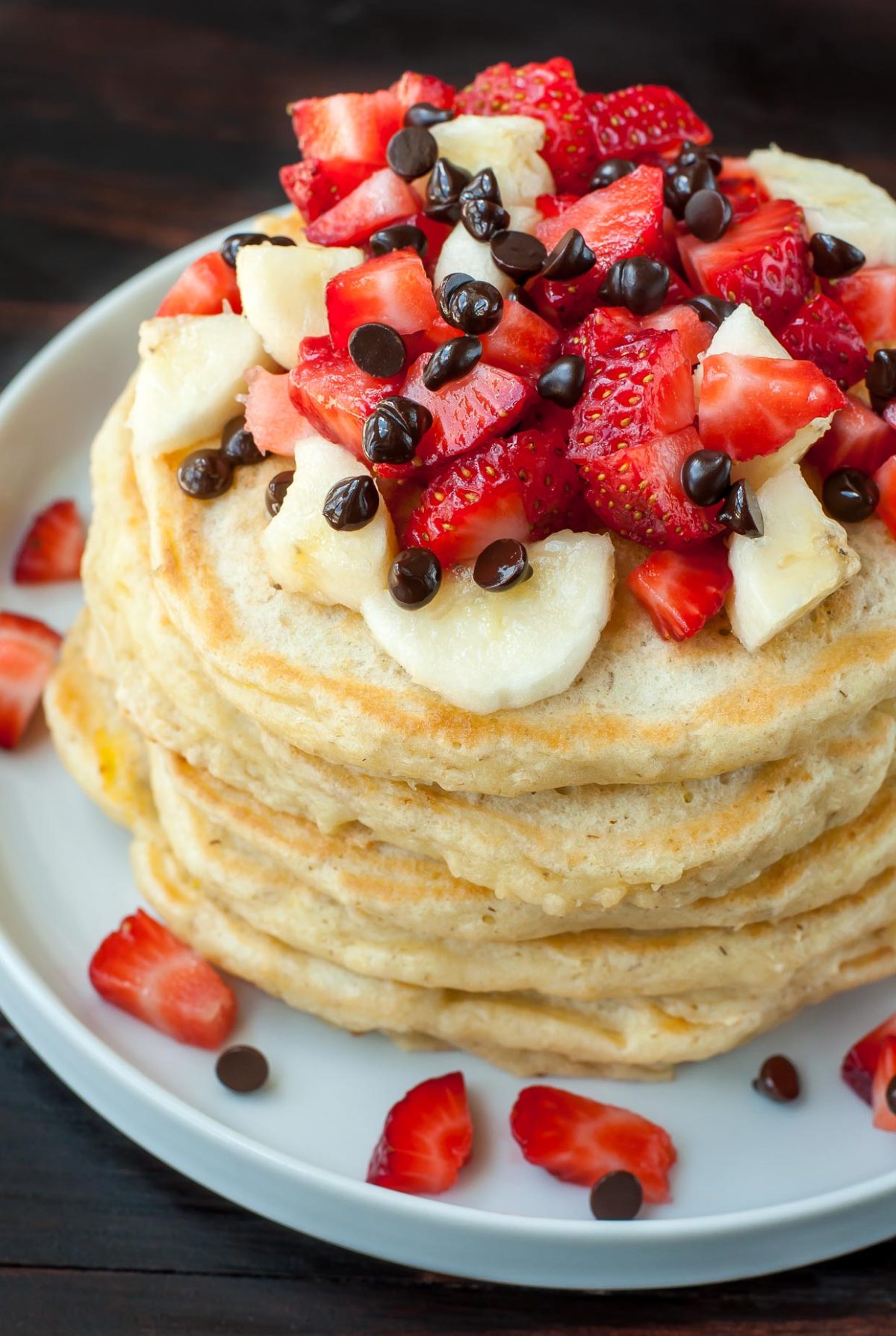Perfectly fluffy pancakes topped with banana, strawberries, and a kiss of dark chocolate chips, these Banana Split Pancakes are a healthy spin on dessert pancakes!