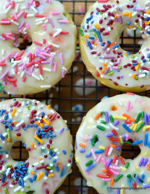 Birthday Cake Doughnuts --- baked doughnut recipe adorned with frosting and sprinkles! theviewfromgreatisland.com