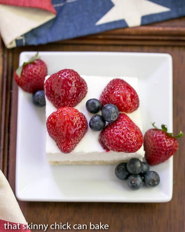 Berry Cheesecake Flag Dessert | Shortbread crust covered with a light whipped cheesecake filling, then decked out like the American flag with luscious, ripe berries!