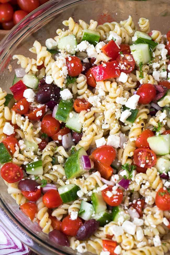 Greek Pasta Salad is an easy side to prep ahead and a hit at every party or potluck! Pasta, ripe juicy tomatoes, crisp cucumbers, feta cheese and olives are tossed in a Greek dressing for the perfect make ahead dish. We often add grilled chicken to make it a perfect meal.
