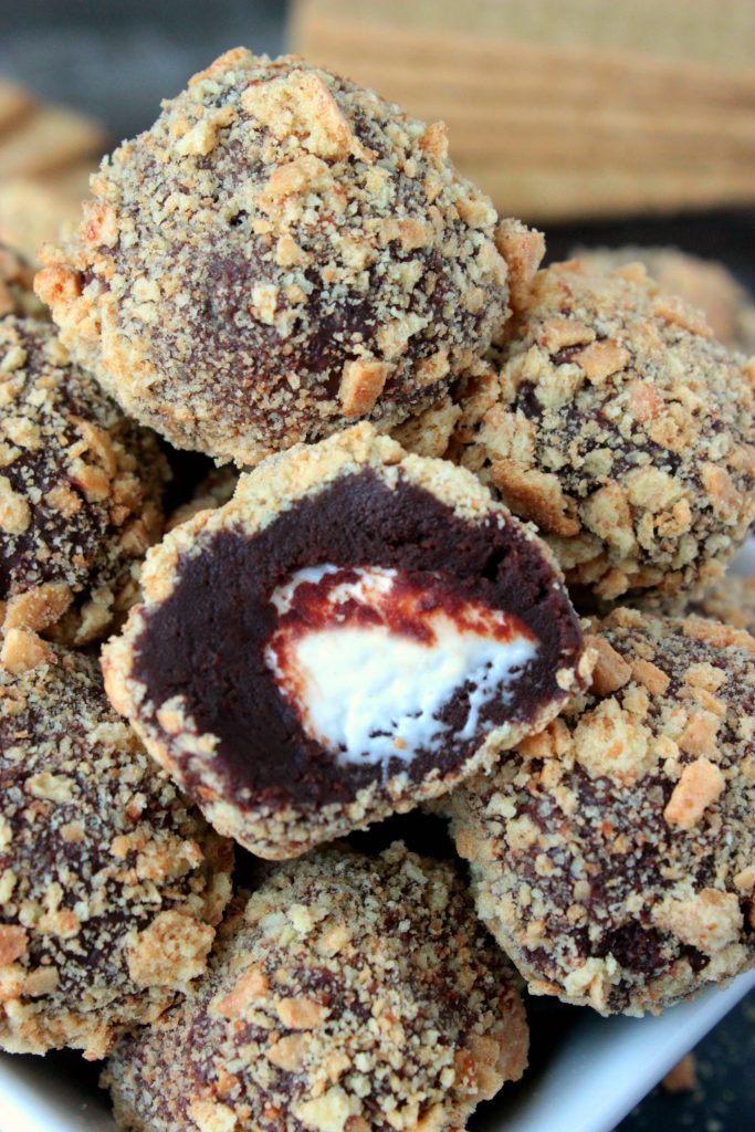 Homemade S'more Truffles - Know a s'more lover in your life? You NEED to send this recipe for Homemade S'more Truffles to them asap! Homemade Chocolate ganache truffles with a marshmallow center that's been rolled in crushed graham crackers is a s'mores lover's dream come true. 