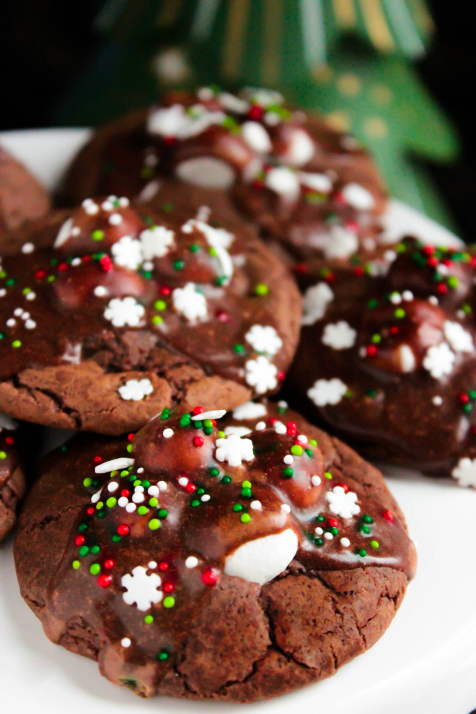 Hot Chocolate Cookies are so popular in our family that I end up making dozens and dozens for family members during the holidays! They’re rich chocolate cookies with melted marshmallows stacked on top with a chocolate glaze drizzle and sprinkles to finish them off.  