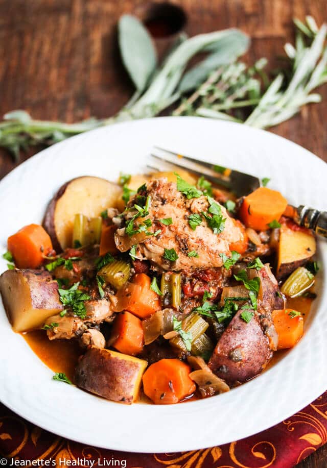 Slow Cooker Chicken Stew in white bowl with fresh herbs
