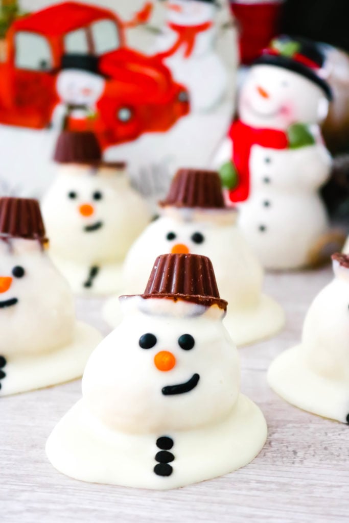 Melting Snowmen Cookie Bites - This adorable dessert is actually homemade snickerdoodles rolled into balls and coated with white chocolate to look like a cute melting snowman. Get the kids involved with this one. This easy recipe can be mastered by chefs of all ages. One part cookie, one part candy, and one part edible art! Melting Snowmen Cookie Bites are sure to be a hit at your holiday parties and winter get-togethers!