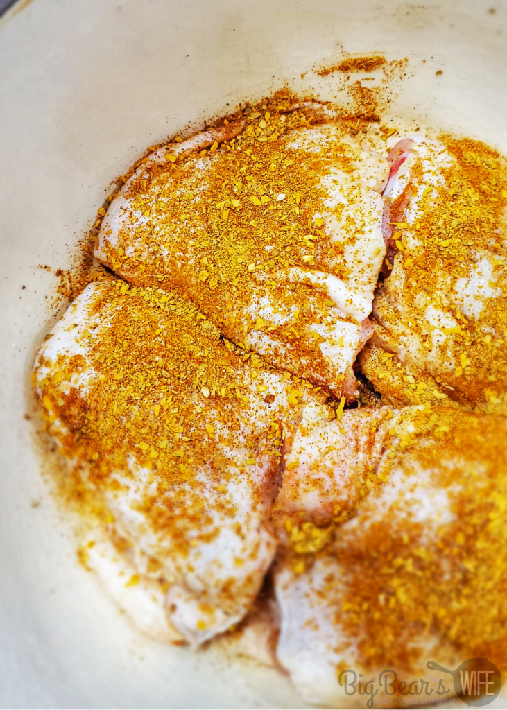 Chicken tights with taco seasoning on them in a cast iron dutch oven