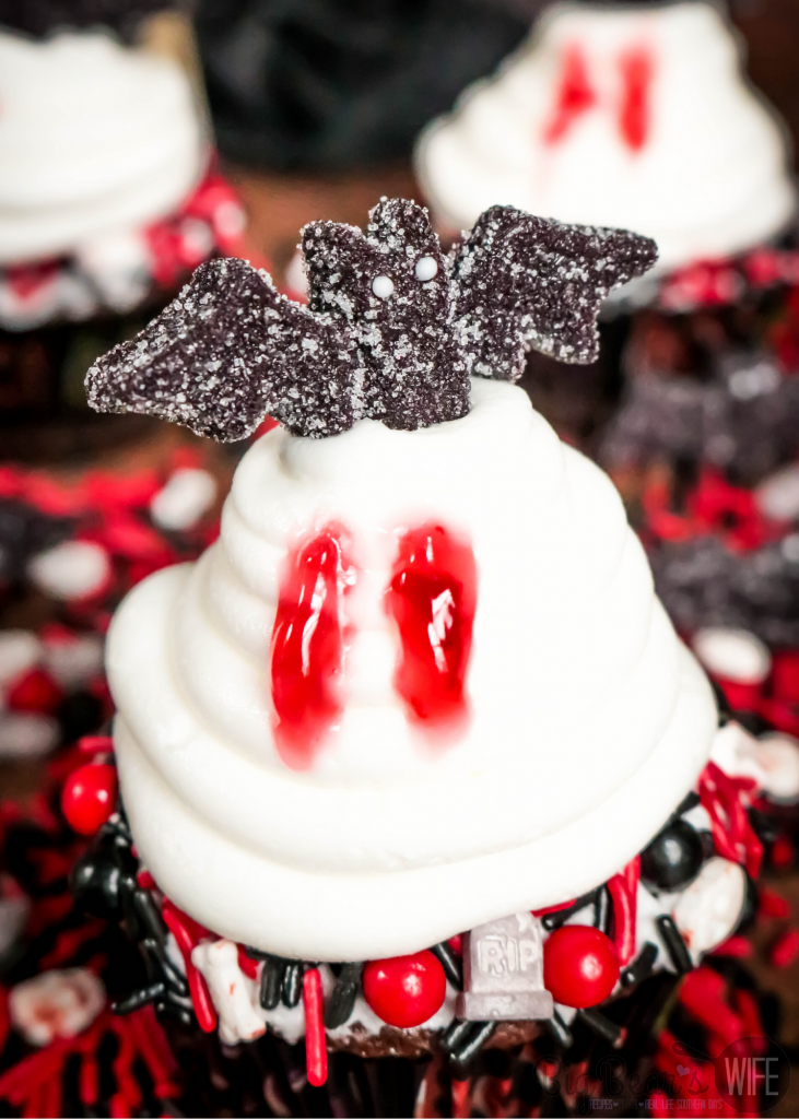 Vampire Bat Cupcakes - Welcome Halloween with these fun and easy Vampire Bat Cupcakes! Vampire bats are resting on top of each cupcake  but they made sure to snag a bite before they did!