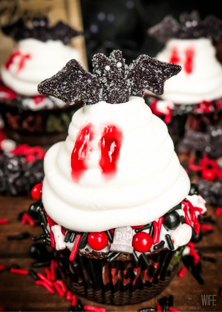 Vampire Bat Cupcakes - Welcome Halloween with these fun and easy Vampire Bat Cupcakes! Vampire bats are resting on top of each cupcake  but they made sure to snag a bite before they did!