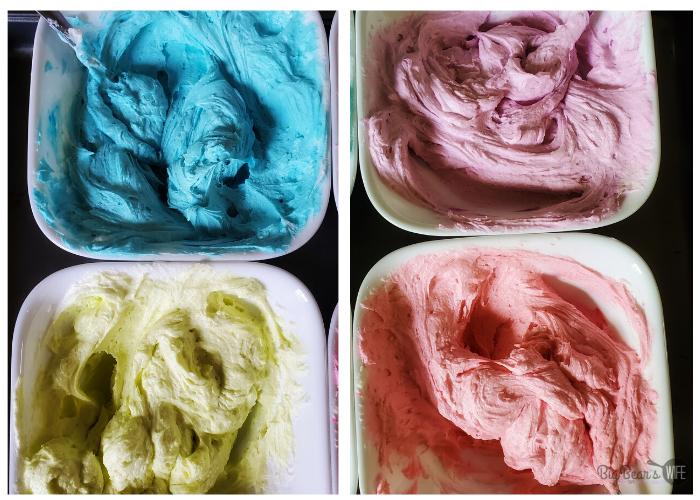 4 colors of frosting in bowls. blue, green, pink and purple