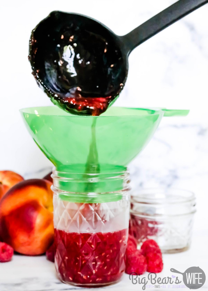 Pouring Raspberry Peach Jam into Clear jar