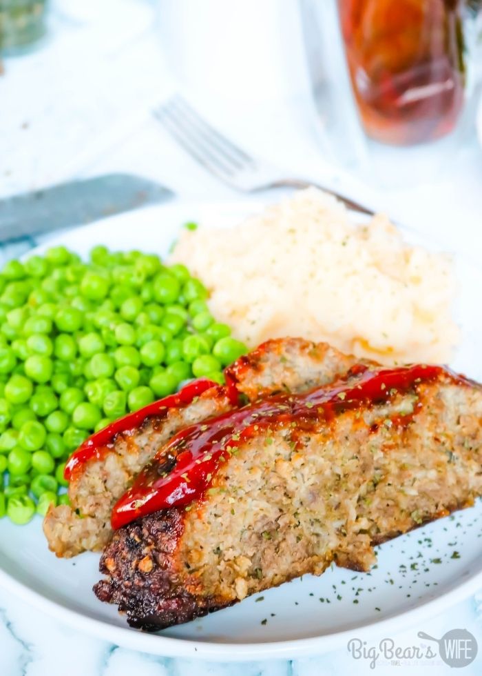 slices of Air Fryer Meatloaf with Peas and Mashed Potatoes on a while plate