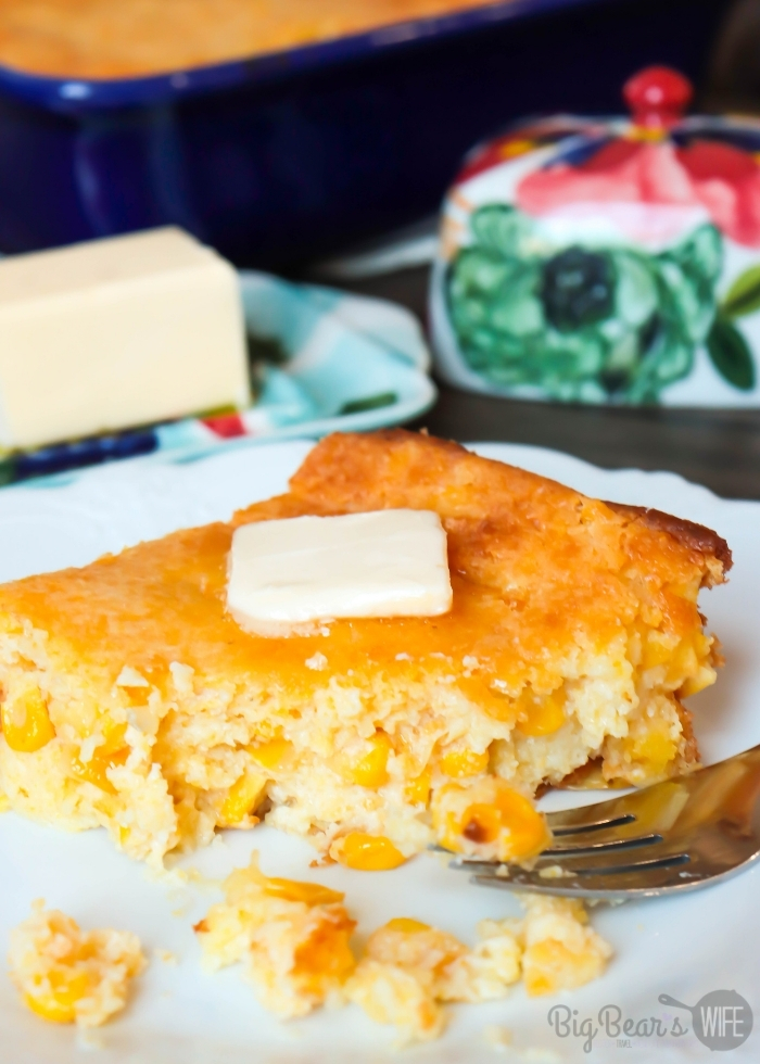 Bite taken from Slice of Creamed Corn Cornbread _ Creamed Corn Casserole with a pat of butter on a white plate