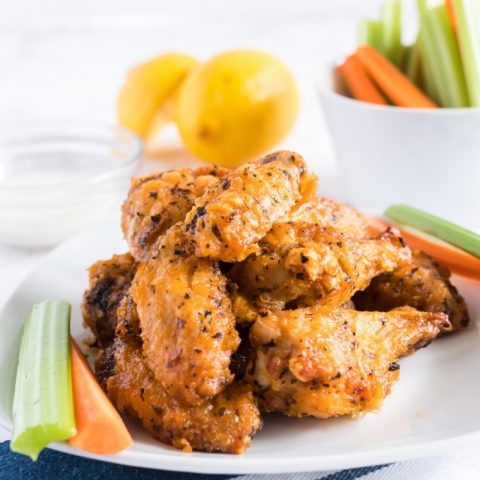 HOT AND HONEY AIR FRYER WINGS on white plate with carrots and celery