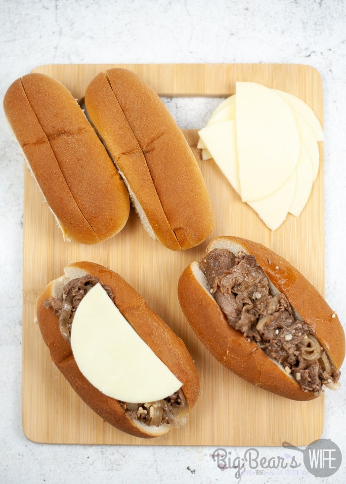adding cheese to Instant Pot French Dip Sandwiches