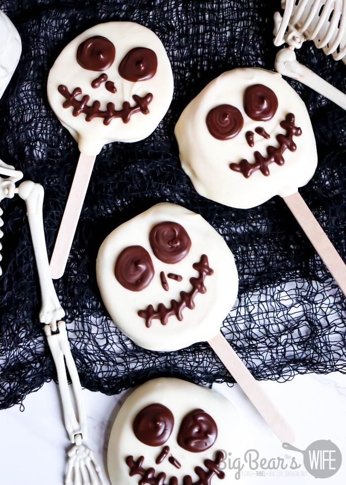 Jack Skellington Apple Slices - Apple slices stuck on a popsicle stick and then dipped in white chocolate candy coating before getting a fun chocolate Jack Skellington face pipped on!
