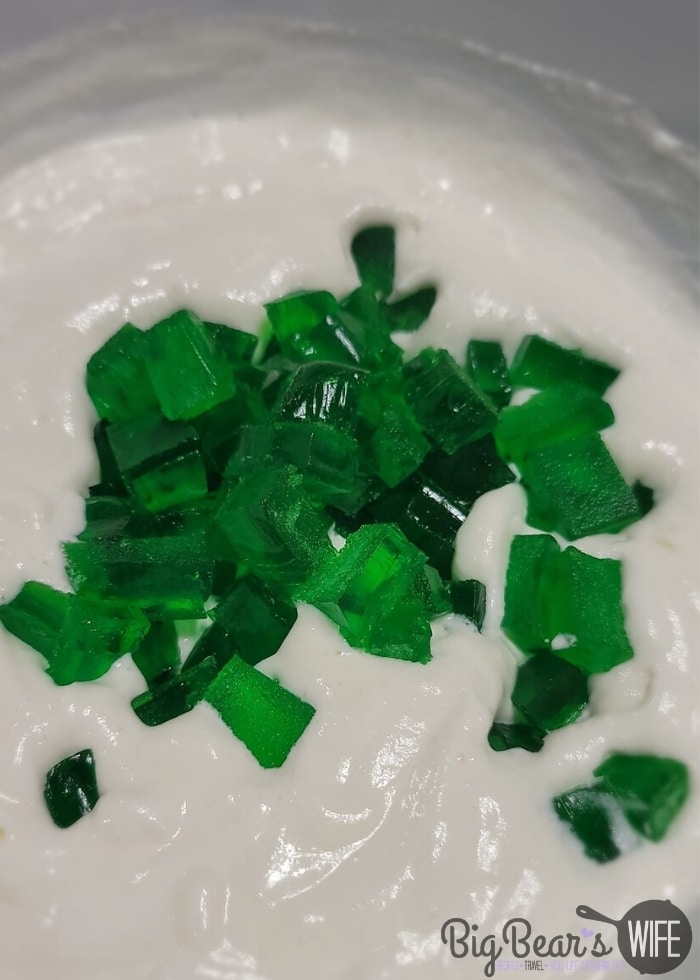 Adding green Jell-O squared to pineapple whipped topping mixture