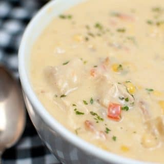 SIDE VIEW CHICKEN CORN CHOWDER IN WHITE BOWL WITH INSTANT POT IN BACKGROUND