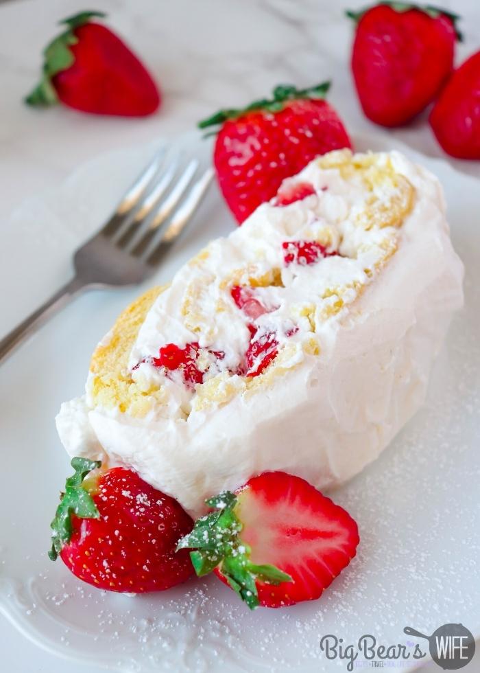 Slice of STRAWBERRY SHORTCAKE ROLL on white plate  in background and strawberries