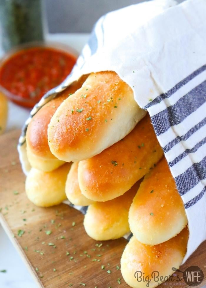 COPYCAT OLIVE GARDEN BREADSTICKs with pizza sauce in the background