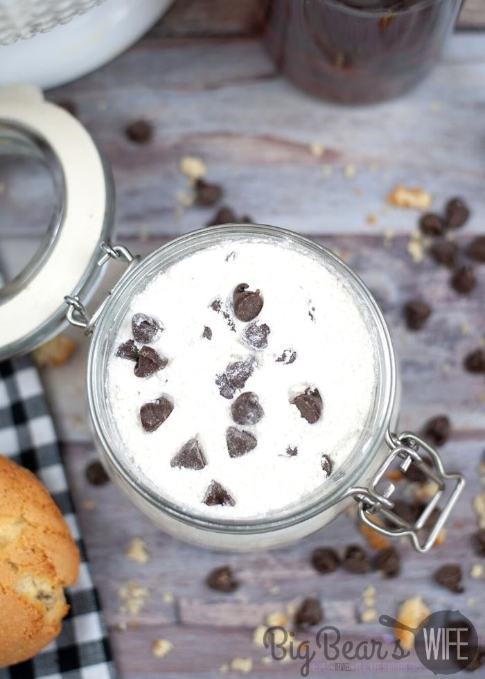 Overhead shot of DRY CHOCOLATE CHIP MUFFIN MIX in a glass jar with chocolate chips scattered around