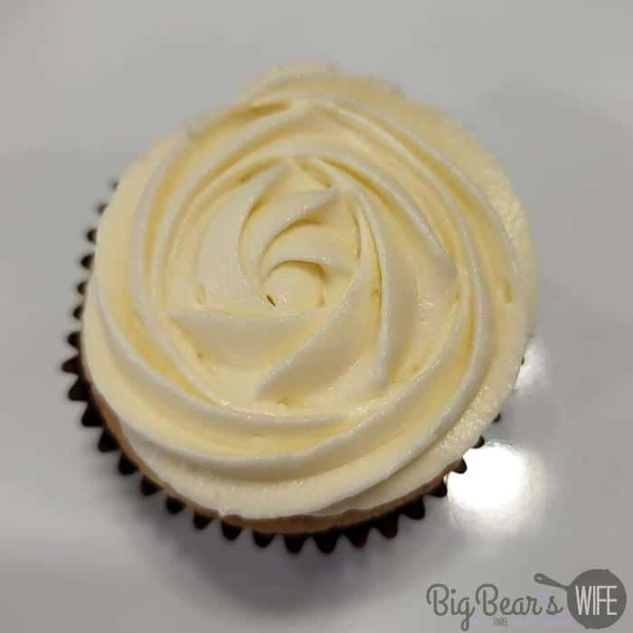 cupcake frosted with white frosting in a rose pattern