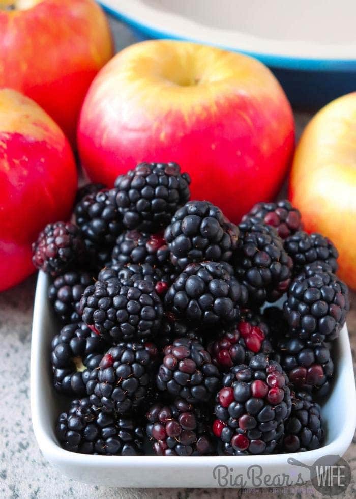 fresh-blackberries-in-white-bowl-with-apples-behind