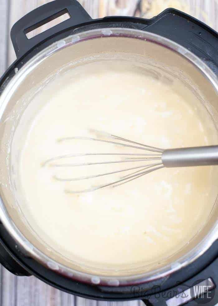 whisking cheese into broth to melt