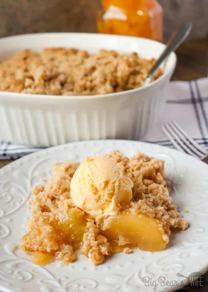 Serving of Easy Apple Dump Cake on white plate with vanilla ice cream on top (1)