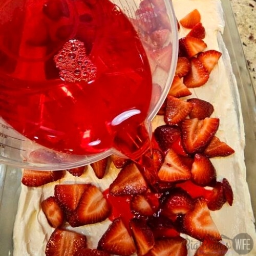 Pouring Jell-O over sliced strawberries