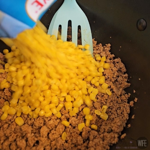 adding corn seasoning to meat