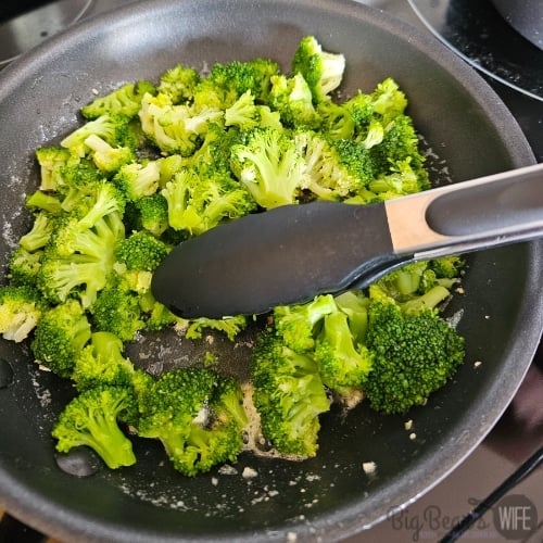 tossing broccoli in garlic butter