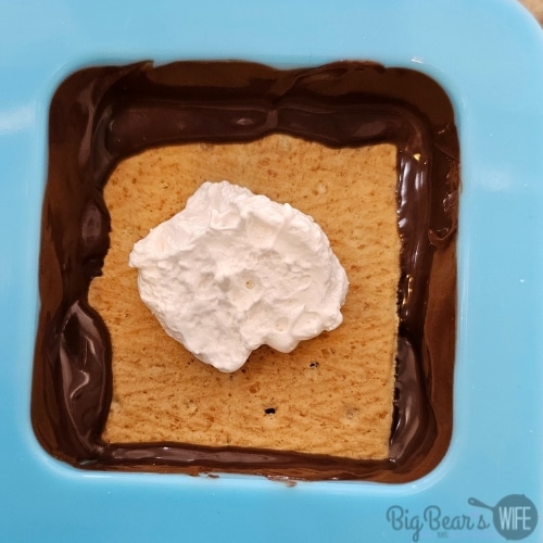 adding marshmallow fluff to graham cracker