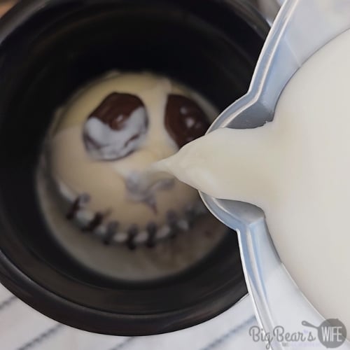 adding milk to Jack Skellington Hot Chocolate Bombs