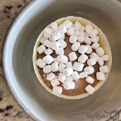 hot coco and marshmallows added to chocolate bowl