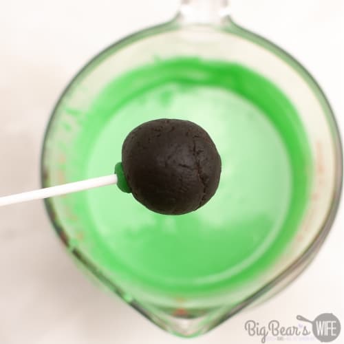 cake pop getting ready to be dipped in green chocolate