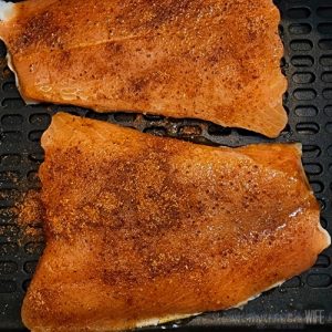 old bay added to raw salmon in air fryer basket