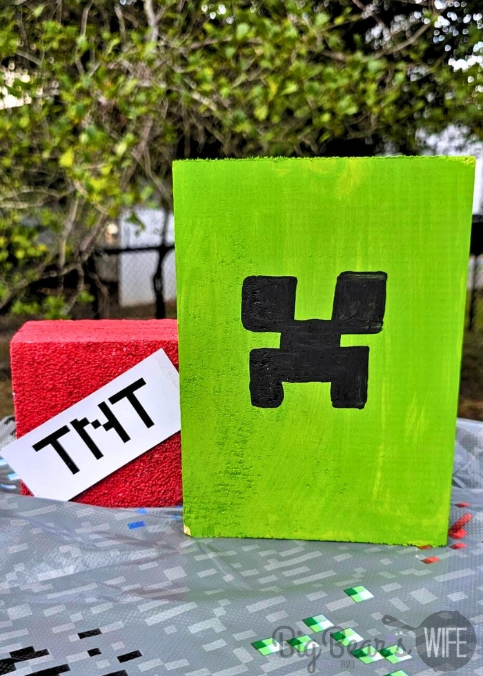 DIY Minecraft party decorations including painted Creeper block and TNT block made with Dollar Tree supplies