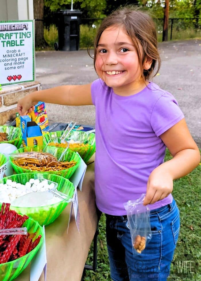 Kids creating their own snack mix at a Minecraft Crafting Table party station